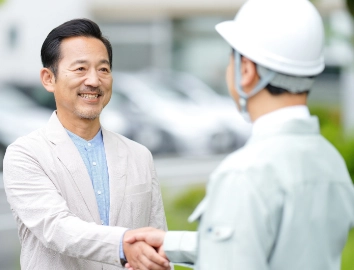 作業員と握手をする男性