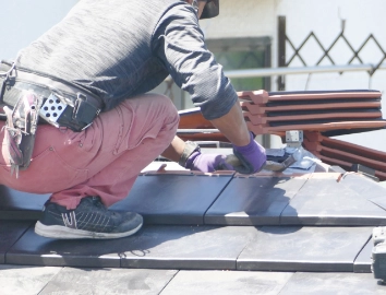 屋根修理をする男性
